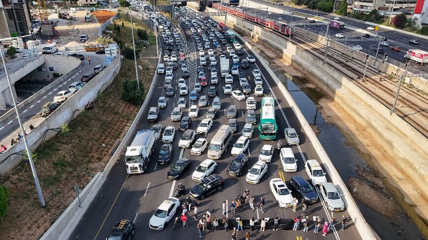Relatives and supporters of Israeli hostages held in Gaza block Ayalon Highway in Tel Aviv, calling for their release 
